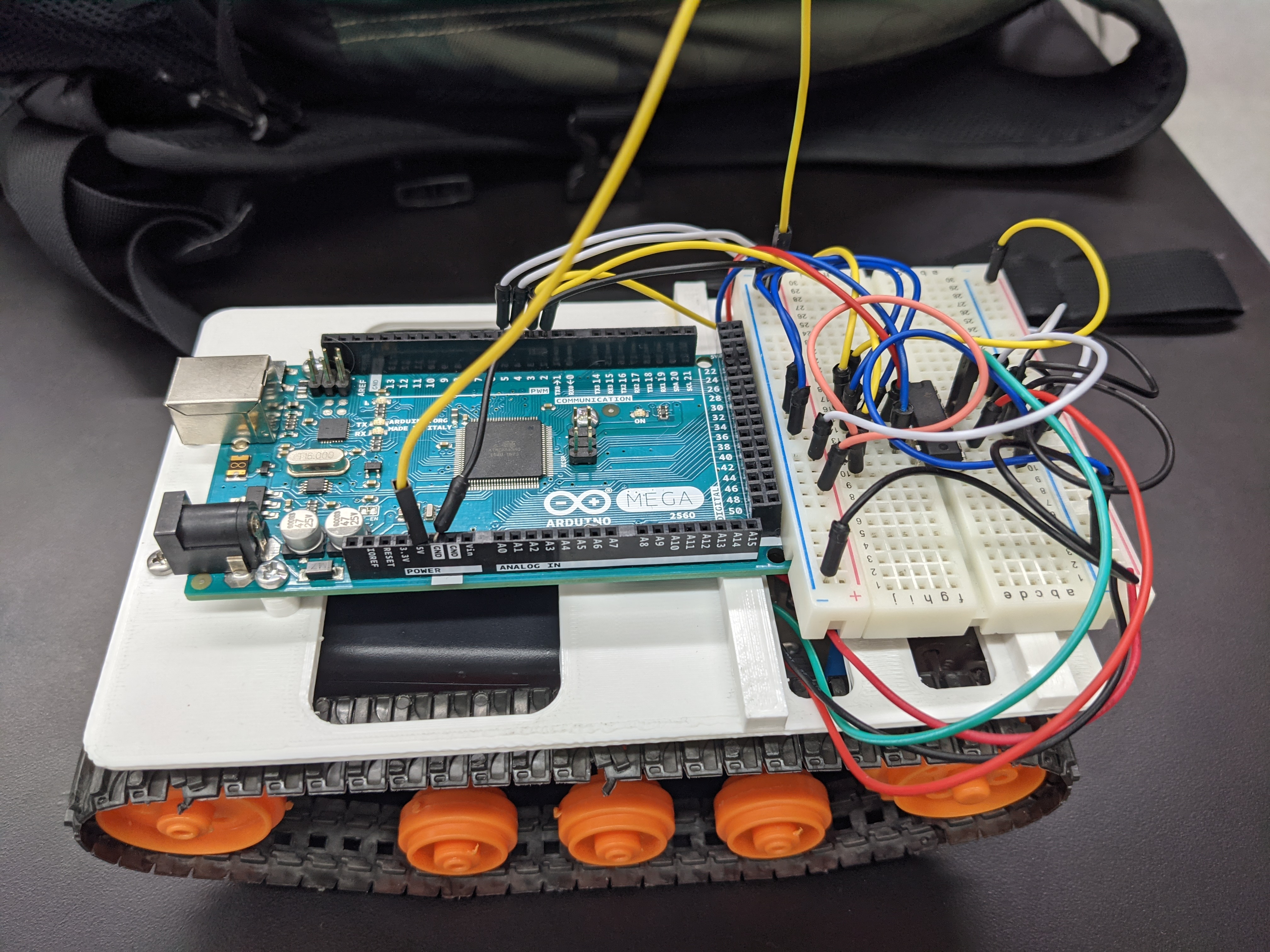 RC tank chassis with Arduino Mega and breadboard mounted on tracked base